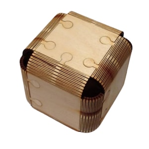 May include: A wooden box with a unique interlocking design. The box is made of light brown wood and has a natural finish. The box is closed and the top is visible.