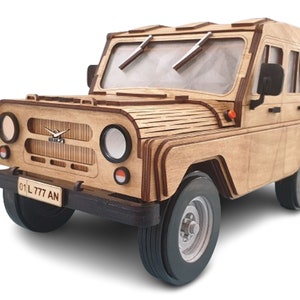 Pode incluir: Um modelo de madeira de um veículo off-road vintage com uma placa de matrícula que lê "01 L 777 AN".
