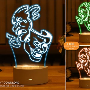 May include: A white 3D printed night light with a design of two theatre masks, one smiling and one frowning. The night light is on a wooden table and has a white base with three small lights on the front.