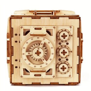 May include: A wooden model of a safe with a combination lock and a working dial. The safe is made of light brown wood and has a realistic design.