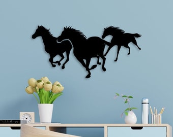May include: Black silhouette wall decor of three horses running in a line. The horses are cut out of a single piece of material and mounted on a light blue wall.