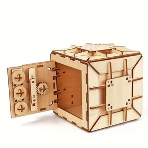 May include: A wooden model of a safe with a working door and a combination lock. The safe is made of light brown wood and has a detailed design.