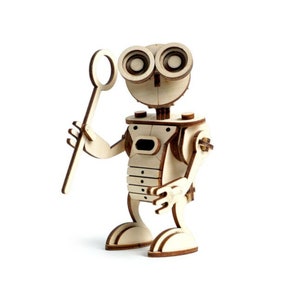 May include: A wooden robot toy with large eyes and a stick in its hand. The robot is made of light brown wood and has a simple design.