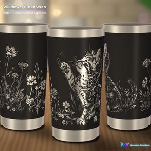 Puede incluir: Tres vasos negros de 591 ml con borde y base de metal plateado. El dise&ntilde;o presenta una ilustraci&oacute;n de l&iacute;neas blancas de un gatito alcanzando hacia arriba rodeado de flores silvestres. El texto superior dice Wildflower Kitten Wrap.