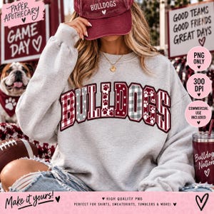 Peut inclure: Un sweat-shirt gris clair à col rond arborant le mot BULLDOGS en grandes lettres de style bloc. Chaque lettre présente un motif différent, notamment un motif écossais rouge et blanc, des rayures grises et blanches et des pattes blanches sur fond rouge.