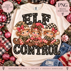 May include: A cream-colored t-shirt featuring a graphic of three elves with various patterned hats and clothing, including leopard print and checkered designs. The text ELF CONTROL is printed in large, black, glittery letters above and below the elves.
