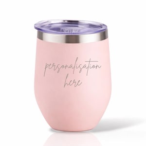 May include: A pale pink insulated wine tumbler with a clear lid and silver rim. The text "personalisation here" is etched on the front. The stemless cup is designed to keep drinks cold. Ideal for picnics and outdoor events.