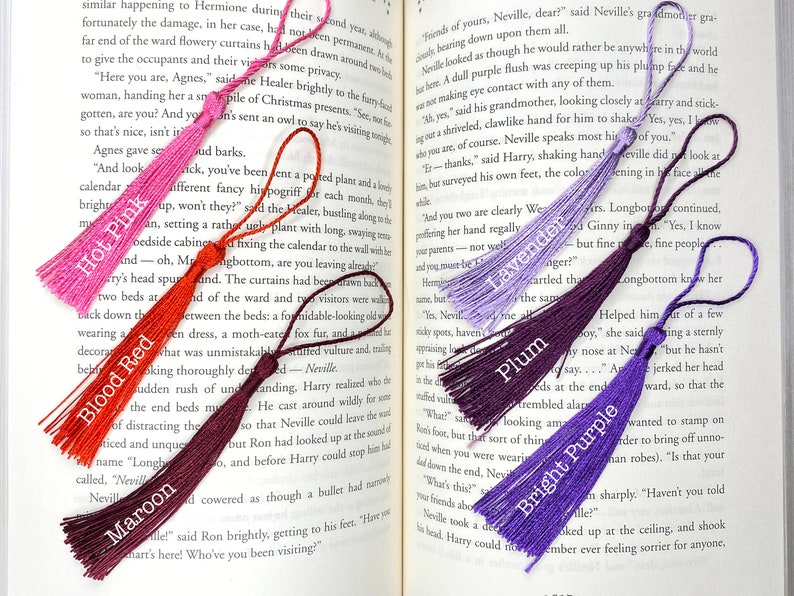 Tassels of varying colors are laid out on the open pages of a book. The tassels are labeled by color.