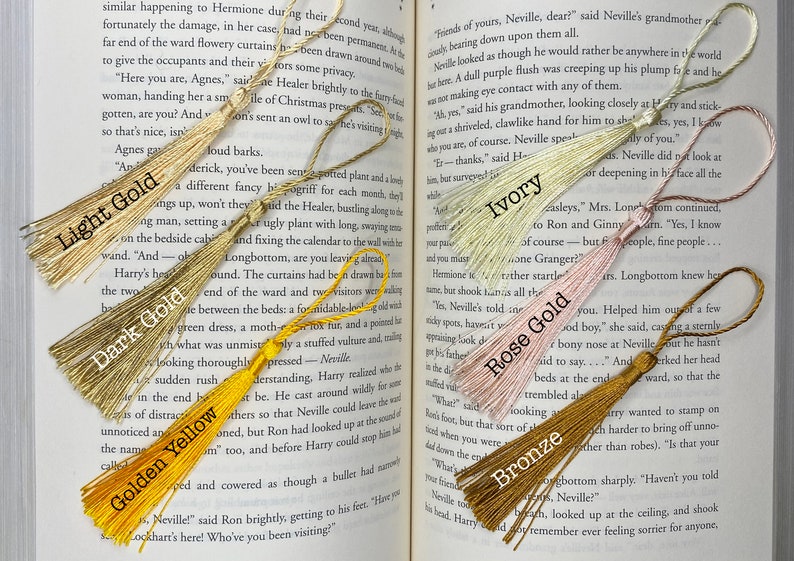 Tassels of varying colors are laid out on the open pages of a book. The tassels are labeled by color.