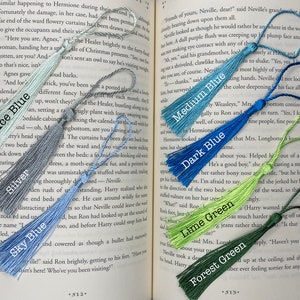 Tassels of varying colors are laid out on the open pages of a book. The tassels are labeled by color.