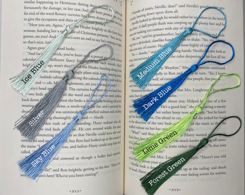 Tassels of varying colors are laid out on the open pages of a book. The tassels are labeled by color.
