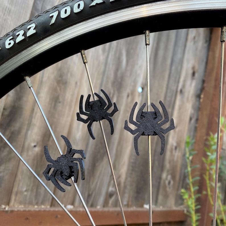 spider themed bike spoke decorations on a bicycle wheel