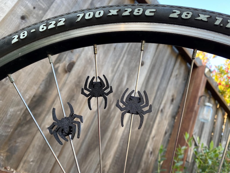 spider themed bike spoke decorations on a bicycle wheel