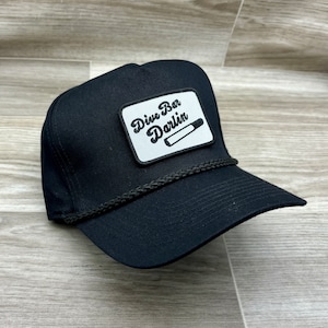 May include: Black trucker hat with a white patch that says "Dive Bar Darlin'" and a cigarette graphic.