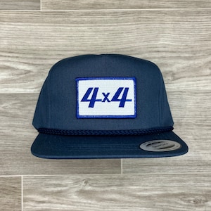 May include: A navy blue baseball cap with a white patch that says "4x4" in blue lettering.