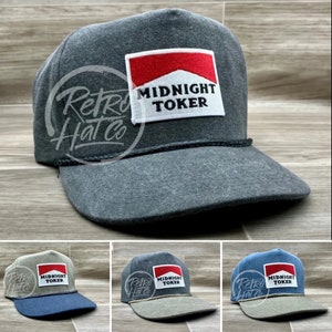 May include: Three trucker hats with a red and white patch that says "Midnight Toker". The hats are gray, beige, and blue.