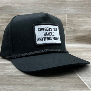 May include: Black trucker hat with a white patch that reads "COWBOYS CAN HANDLE ANYTHING HORNY".