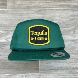 May include: A dark green baseball cap with a black and yellow patch that reads "Tequila Helps" with agave plant illustrations.