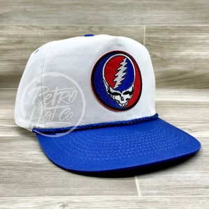 May include: White and blue trucker hat with a Grateful Dead Steal Your Face logo patch. The patch is red, white, and blue with a lightning bolt.