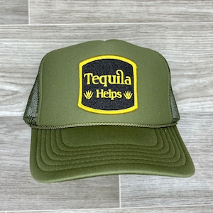 May include: A green trucker hat with a black and yellow patch that says "Tequila Helps" with a stylised agave plant on either side of the text.