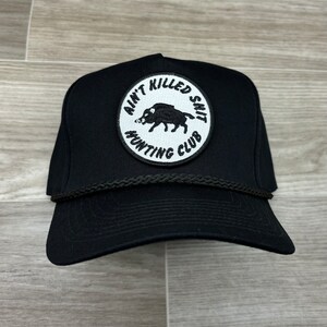 May include: Black trucker hat with a white patch that says "Ain't Killed Shit Hunting Club" and features a black boar illustration.