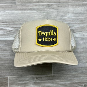 May include: A beige trucker hat with a black and yellow patch that reads "Tequila Helps".