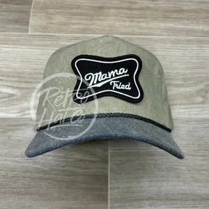 May include: A green and black trucker hat with a black patch that says "Mama Tried" in white text.