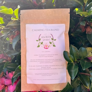 May include: A brown paper pouch with a white label that reads "Calming Tea Blend" and "New Moon Naturals". The label lists the ingredients of the tea blend, which includes tulsi, skullcap, chamomile, lemon balm, lavender, rosemary, California poppy, and ashwagandha root. The label also includes instructions for brewing the tea.