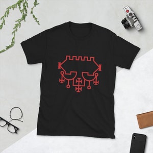 Puede incluir: Camiseta negra con un diseño de sello rojo. El sello es un patrón geométrico complejo con una cruz central y varios círculos.
