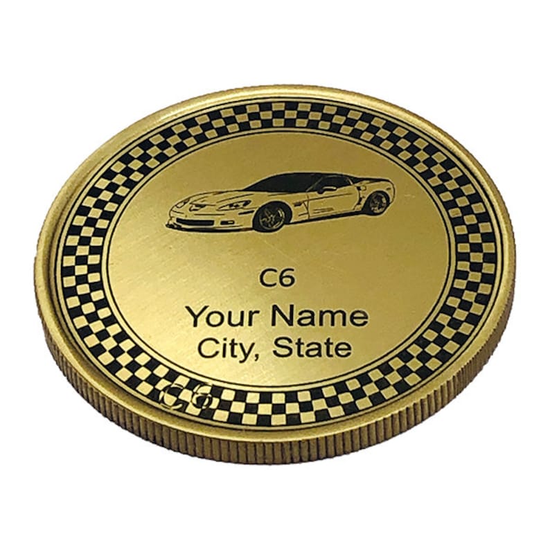 May include: Gold-colored coin with a black and white checkered border. The center features a black and white image of a Corvette C6 with the text "C6 Your Name City, State".