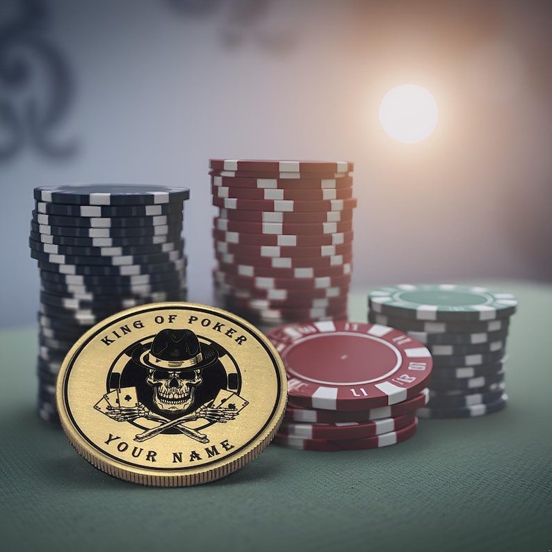 May include: A gold poker chip with a skull wearing a hat and the text "King of Poker" and "Your Name". The chip is surrounded by stacks of poker chips in red, black, and green.