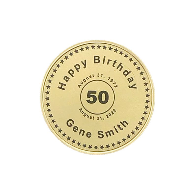 May include: Gold-colored round coin with a black inscription that reads "Happy Birthday" with a star border. Inside the border is a circle with the text "August 31, 1972" and "August 31, 2022" and the number "50" in the center. Below the circle is the text "Gene Smith".