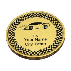 May include: Gold-colored coin with a black and white checkered border. The center of the coin features a black and white image of a Corvette C5 car. The text "C5 Your Name City, State" is printed below the car.