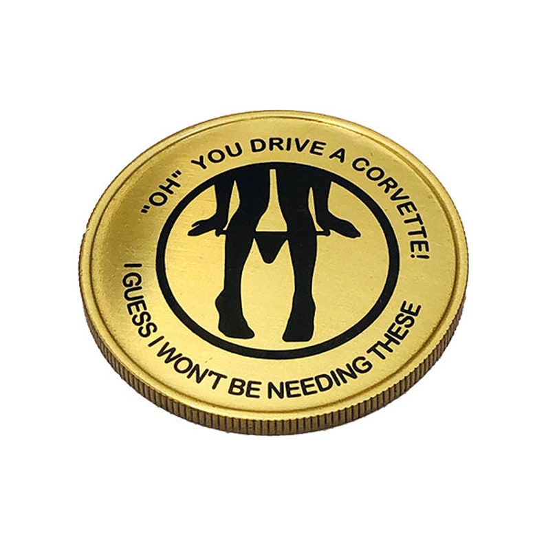 May include: A gold-colored coin with a black silhouette of a person pulling down their underwear. The text on the coin reads "'OH' YOU DRIVE A CORVETTE! I GUESS I WON'T BE NEEDING THESE"