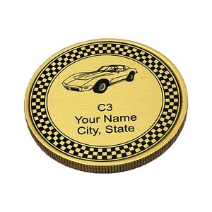 May include: Gold-colored coin with a black and white checkered border. The center of the coin features a black and white silhouette of a Corvette C3 car. The text "C3", "Your Name", and "City, State" is printed in black below the car.