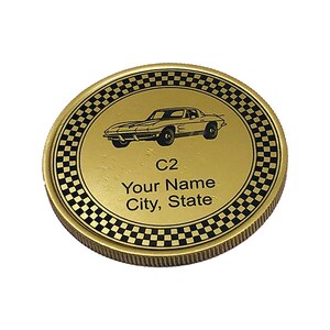 May include: Gold-colored coin with a black and white checkered border. The center of the coin features a black silhouette of a classic Corvette car. The text "C2", "Your Name", and "City, State" is printed below the car.