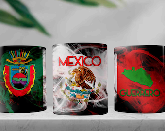 May include: Three white ceramic mugs with different designs. The first mug has a green, black, and red design with the text "MEXICO" and a stylized eagle. The second mug has a green, black, and red design with a stylized coat of arms. The third mug has a red, black, and green design with the text "GUERRERO" and a stylized map of the state.