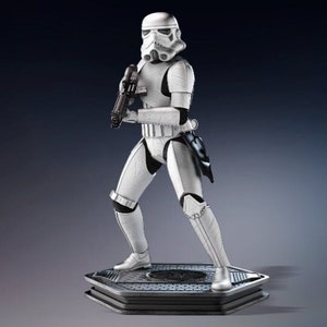 Op de afbeelding: Een wit Stormtrooper-actiefiguur met een zwart blastergeweer, staand op een zeshoekige basis. De figuur is zeer gedetailleerd en heeft een verweerde uitstraling.