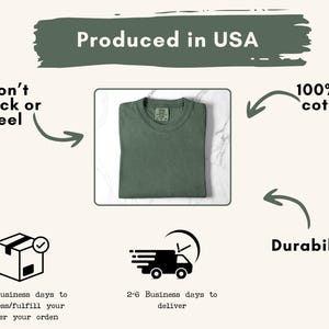 May include: A folded, olive green t-shirt is centered on a white surface. The text "Produced in USA" is above the shirt. Additional text includes "Won't Crack or Peel", "100% US cotton", and "Durability".
