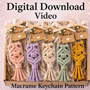 May include: A cardboard box containing five macrame keychains in pink, lavender, cream, sage green, and mustard yellow. Each keychain is individually wrapped in clear plastic with a beige tag reading Thank you with a white heart icon and a cream ribbon.