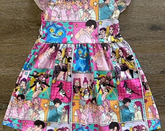 May include: A sleeveless dress featuring a vibrant comic book-style print. The dress showcases a repeating pattern of colorful panels with anime-style characters, a blue cat, and various graphic elements. The dress has a flared skirt and ruffled sleeves.