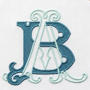 May include: An embroidered monogram featuring the letters A and B on a white fabric background. The letter B is stitched in a dark teal thread with decorative flourishes, while the letter A is stitched in a lighter mint green thread.