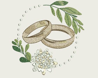 May include: Embroidered design featuring two intertwined gold wedding rings, surrounded by green leaves, a white flower, and a dotted border on a cream background. The design evokes a sense of romance and celebration.