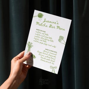 May include: A white menu titled "Jasmine's Matcha Bar Menu" is held by a hand. The menu lists matcha drinks and sweet and savory bites, with illustrations of matcha-related items in green. The "grow & glow" logo is at the bottom.