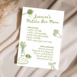May include: A white menu card with green illustrations and text for Jasmine's Matcha Bar. The menu lists matcha drinks and sweet and savory bites, including matcha oat latte, almond croissant, and basque burnt cheesecake.