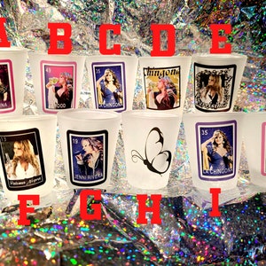 May include: Set of ten shot glasses with images of a woman singing and the text "La Reina", "Mood", "La Chingona", "Chingona", "La Chingona", "Jenni Rivera", "La Chingona", and "7".