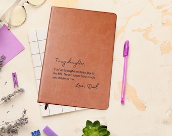 May include: A brown leather journal with the inscription "To my daughter, You've brought endless joy to my life. Never forget how much you mean to me. Love, Dad"