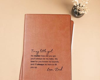 May include: A brown leather journal with a heartfelt message engraved on the front: "To my little girl, No matter how old you get, you'll always be my baby. My love for you knows no bounds, and I'll always be here to lift you up. Love, Dad"
