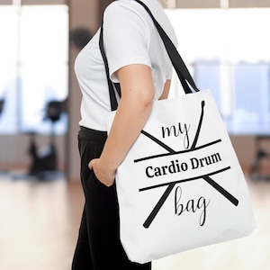 May include: White canvas tote bag with black straps and the text "my Cardio Drum bag" printed on the front. The text is surrounded by two crossed drumsticks.