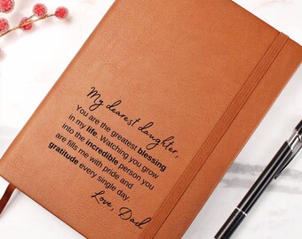 May include: A brown leather journal with a personalized message that reads "My dearest daughter, You are the greatest blessing in my life. Watching you grow into the incredible person you are fills me with pride and gratitude every single day. Love, Dad."